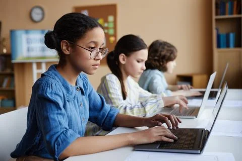 School children studying with computers in class Stock Photos