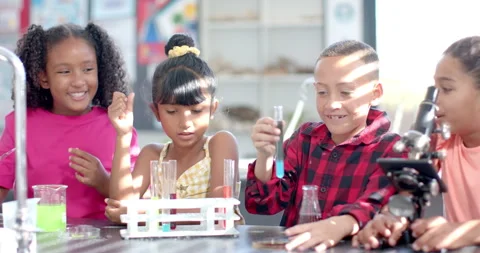 In a school classroom, a diverse group of young students engages in a chemistry Stock Footage 300421708
