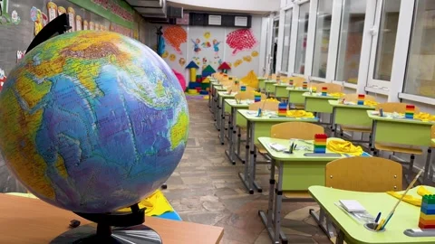 School classroom. There is a globe on the teacher's desk. Desks with school Stock Footage 254802578