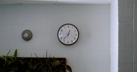 School clock on wall on solid cinder block wall in cafeteria, 4K Stock Footage 118141729