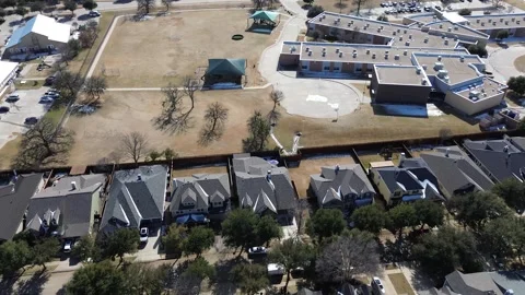 School complex sits beside upscale residential neighborhood streets Stock Footage 328350728