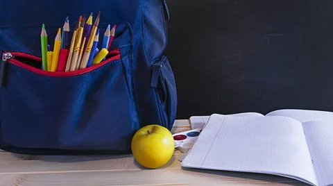 School concept backpack on desk with school accessories and copy space on chalk Stock Photos