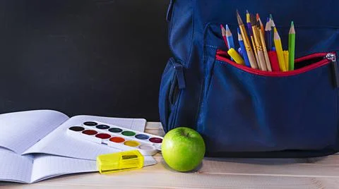 School concept backpack on desk with school accessories and copy space on chalk Stock Photos