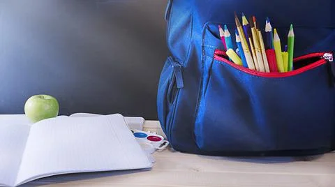 School concept, blue backpack with pencils on the table in front of the chalk Stock Photos
