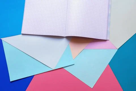 School concept. Colored paper sheets and notebook. Copy space Stock Photos