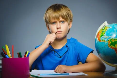School concept. doubt, expression - boy thinking over gray background Stock Photos