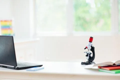 School desk with microscope. Science class. Stock Photos