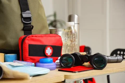School desks with emergency backpack, first aid kit and necessities in classr Stock Photos