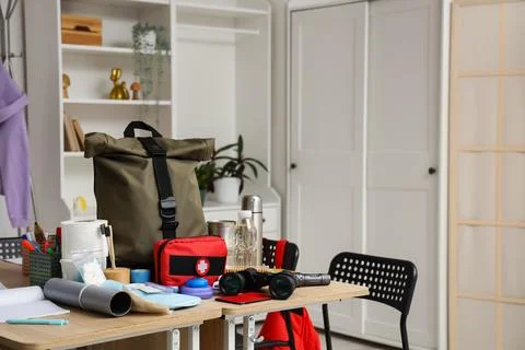 School desks with emergency backpack, first aid kit and necessities in classr Stock Photos