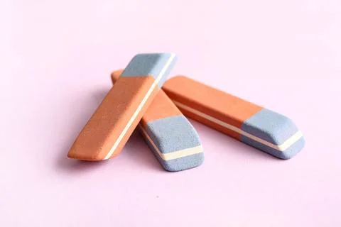 School erasers on lilac background Stock Photos