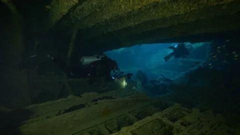 School of fish, divers in the hold of the shipwreck Thistlegorm, Red Sea, Egypt Stock Footage 105459205