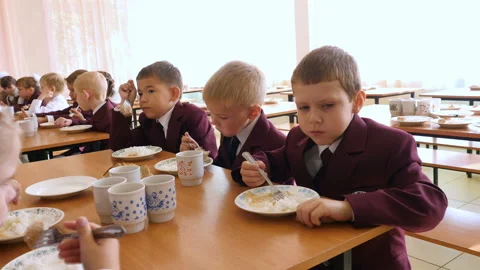 School food - a group of elementary school children eating a school lunch Stockbeeldmateriaal 88327837