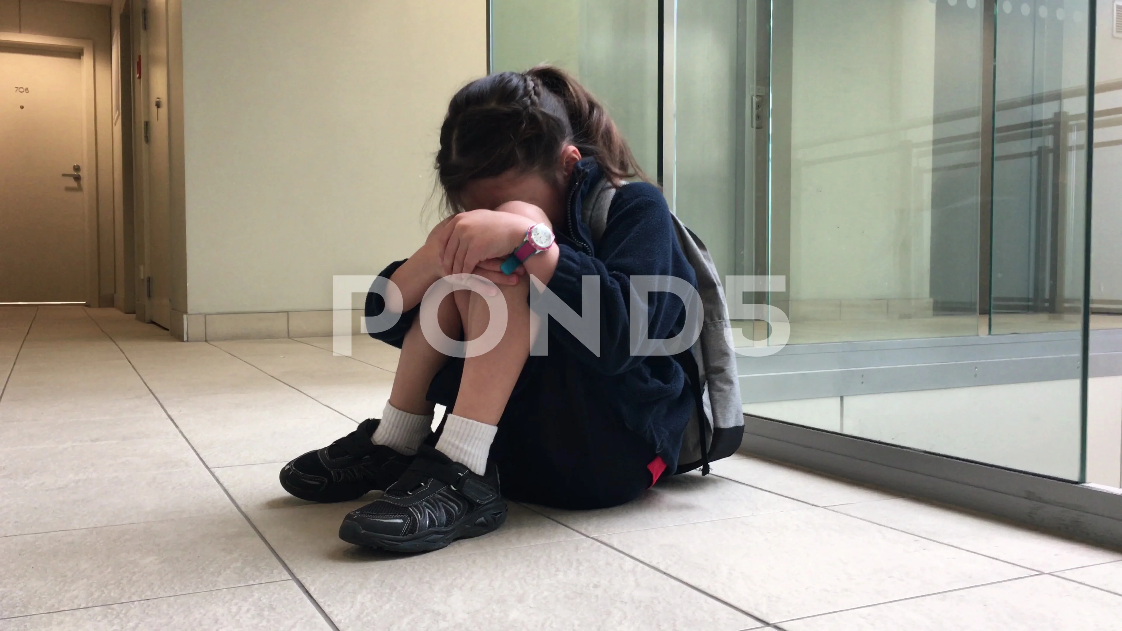 3840px x 2160px - School girl sitting on a corridor floor ... | Stock Video | Pond5