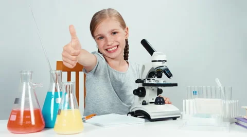 School girl using microscope very carefully. Thumb up. Ok Video stock 65453244