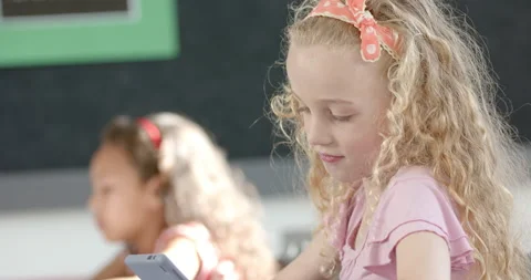 In school, girl using tablet in classroom, focusing on screen 動画素材 300333215