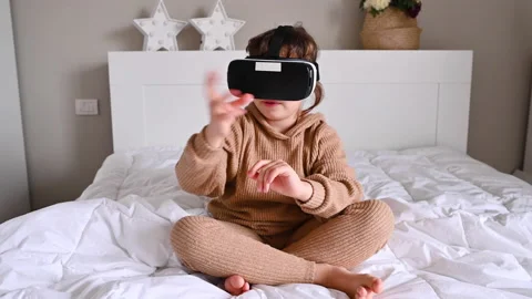 School girl using VR glasses and exploring virtual worlds. Little girl wearing v 動画素材 143599596
