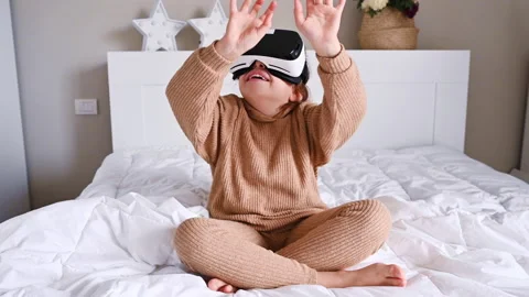 School girl using VR glasses and exploring virtual worlds. Little girl wearing v Video stock 143599899