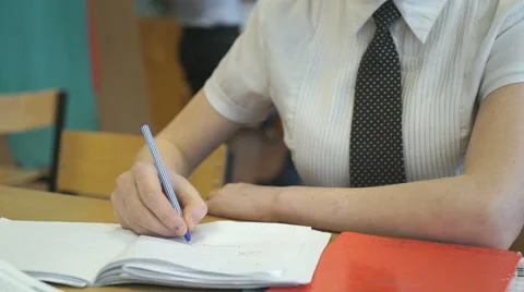 A school girl writes in a notebook using a pen 動画素材 62652053