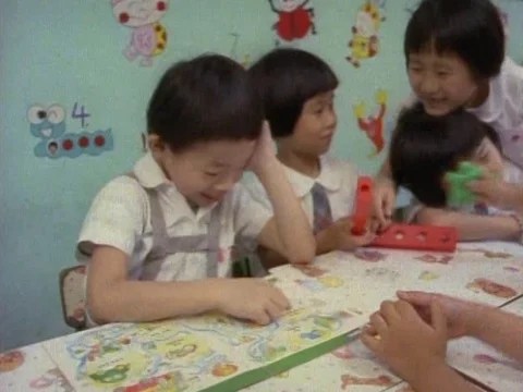 School girls inside the classroom having a fun time as they sit around the table Stock Footage 79878842
