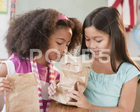 School girls looking into lunch bag Stock Photos