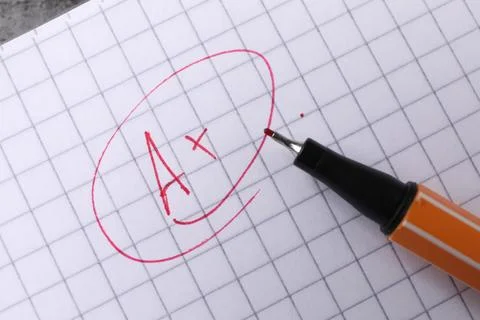 School grade. Red letter A with plus symbol on notebook paper and pen, top vi Stock Photos