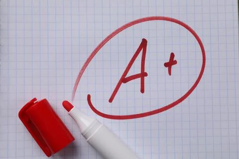 School grade. Red letter A with plus symbol on notebook paper and marker, t.. Stock Photos