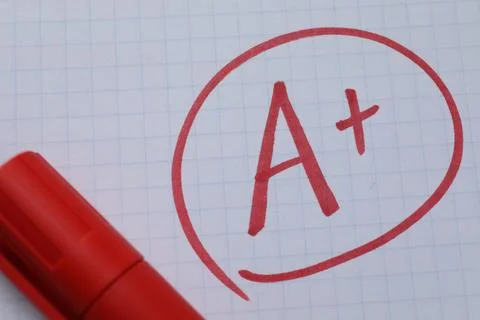 School grade. Red letter A with plus symbol on notebook paper and marker, t.. Stock Photos