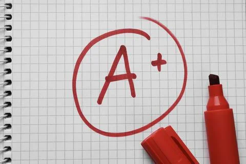 School grade. Red letter A with plus symbol on notebook paper and marker, t.. Stock Photos