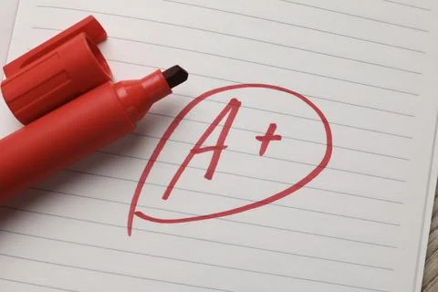 School grade. Red letter A with plus symbol on notebook paper and marker, t.. Stock Photos