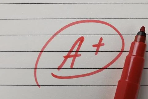 School grade. Red letter A with plus symbol on notebook paper and marker, t.. Stock Photos