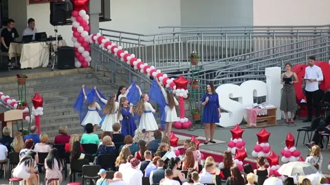 School Graduation Celebration. Junior students sing and dance in front of gra Stock Footage 132413960