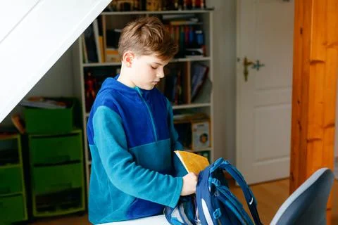 School kid boy getting ready in the morning for school. Healthy child filling Stock Photos