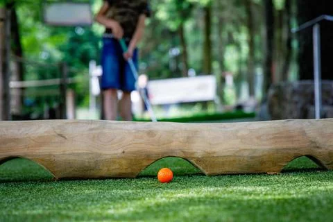School kid boy playing mini golf with family. Happy child having fun with 写真素材