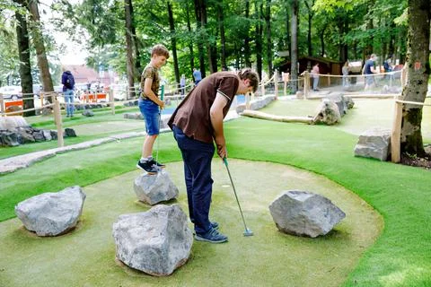 School kid boy playing mini golf with father. Happy child and dad, young man Stock-Fotos