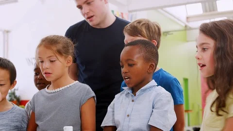 School kids and teacher watch experiment at a science centre Stock Footage