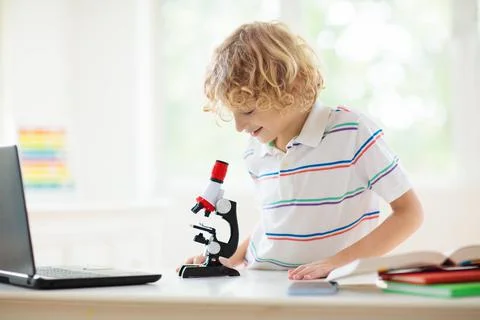 School kids with microscope. Science class. Photos