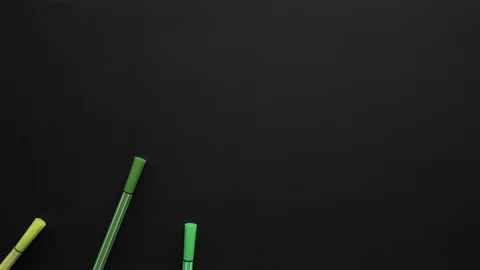 School markers of different colors are located on the black surface. Stop motion Stock Footage 108475741