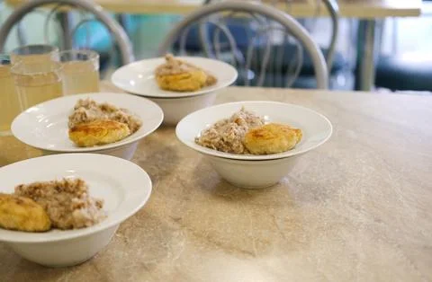 School meals featuring nutritious servings of grain and protein on white plates Stock-Fotos