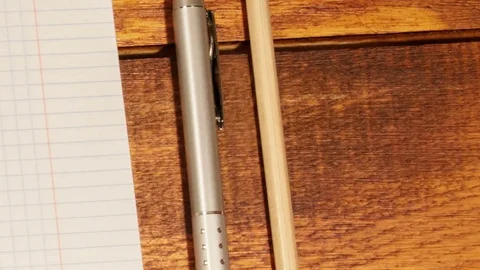 School notebook in a cage with pen and pencil on wooden table Video stock 73289102
