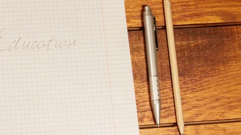 School notebook in a cage with pen and pencil on wooden table Stock Footage 73289147