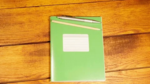 School notebook in a cage with pen and pencil on wooden table Stock Footage 73293319