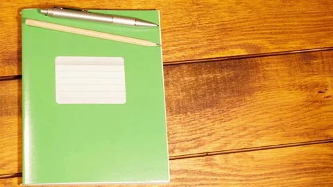 School notebook in a cage with pen and pencil on wooden table Stock Footage 73293578