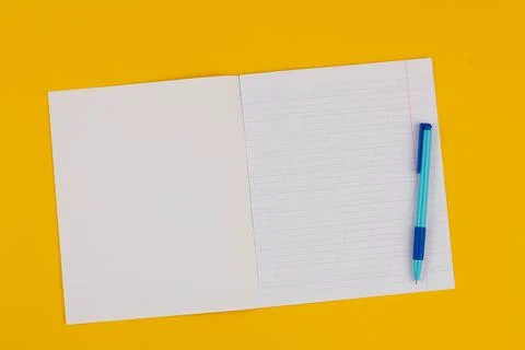 School notebook on a yellow background with copy space for text and blue pen Stock Photos