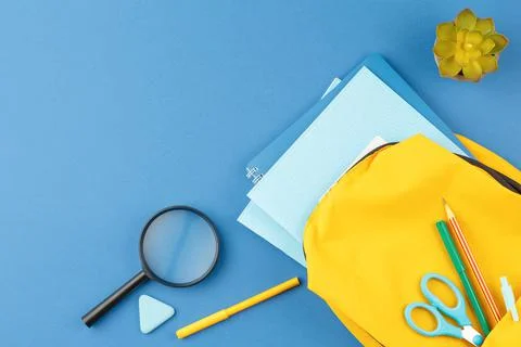 School notepad with study supplies on blue desk. Foto stock