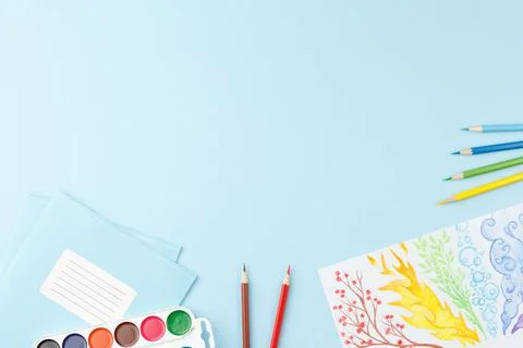 School notepad with study supplies on blue desk. Stock Photos