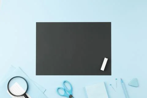 School notepad with study supplies on blue desk. Stock Photos