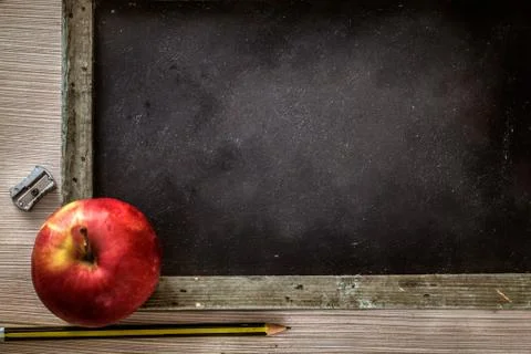 School objects for students. Chalkboard, pencils, crayons and apple Stock Photos