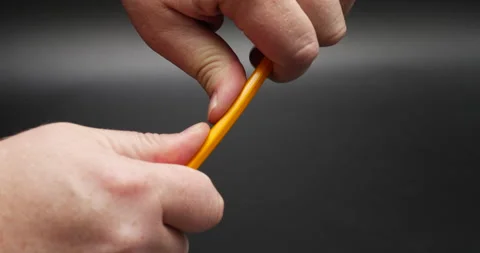 School pencil breaking in half isolated on black hands close up  Stock Footage 163479419