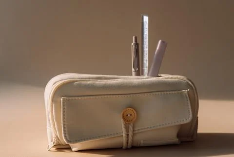School pencil case with pens in dramatic warm sunlight, back to school still 스톡 사진