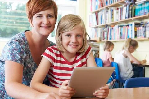 School pupil with teacher using digital tablet computer in classroom Stock Photos